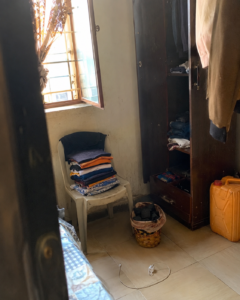 small Nigerian hostel room with charcoal odor absorber and clean laundry setup