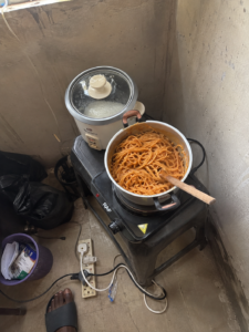 Single burner and rice cooker set up in a Nigerian hostel room corner