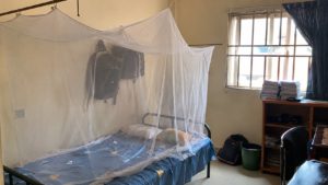 Mosquito net set up over a bed in a Nigerian hostel room