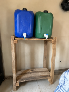 Homemade wooden stand for hostel water storage jerrycans