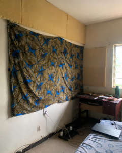 DIY foam and fabric soundproofing on a thin Nigerian hostel room wall